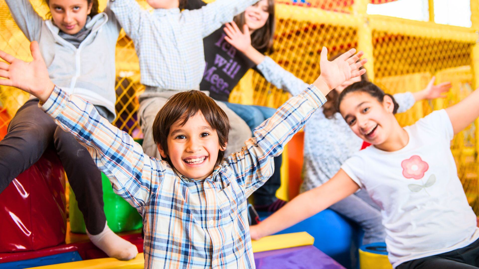 Little boy and his friends are happy to be playing in an indoor playground